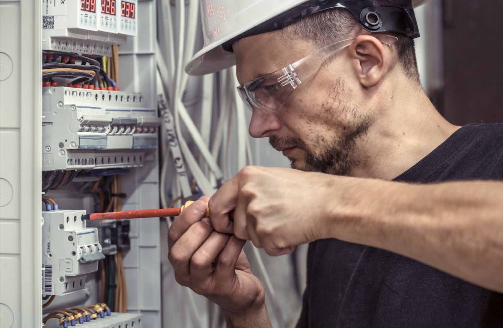 A close-up of a skilled electrical contractor carefully working on a switchboard, connecting electrical cables with precision and attention to detail, ensuring proper functionality and safety.