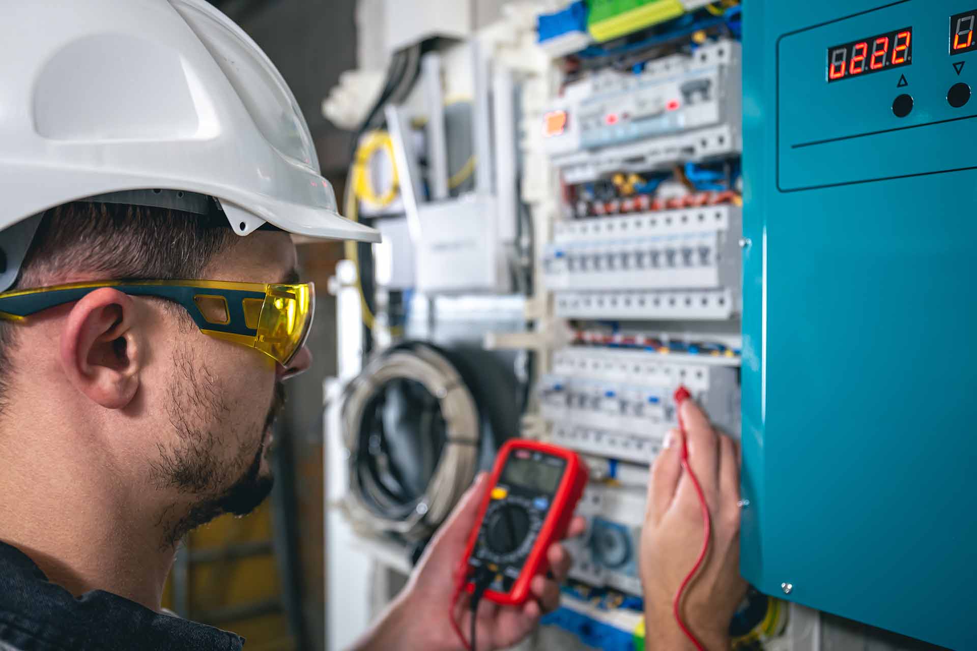 A male electrician is busy fixing the switchboard.