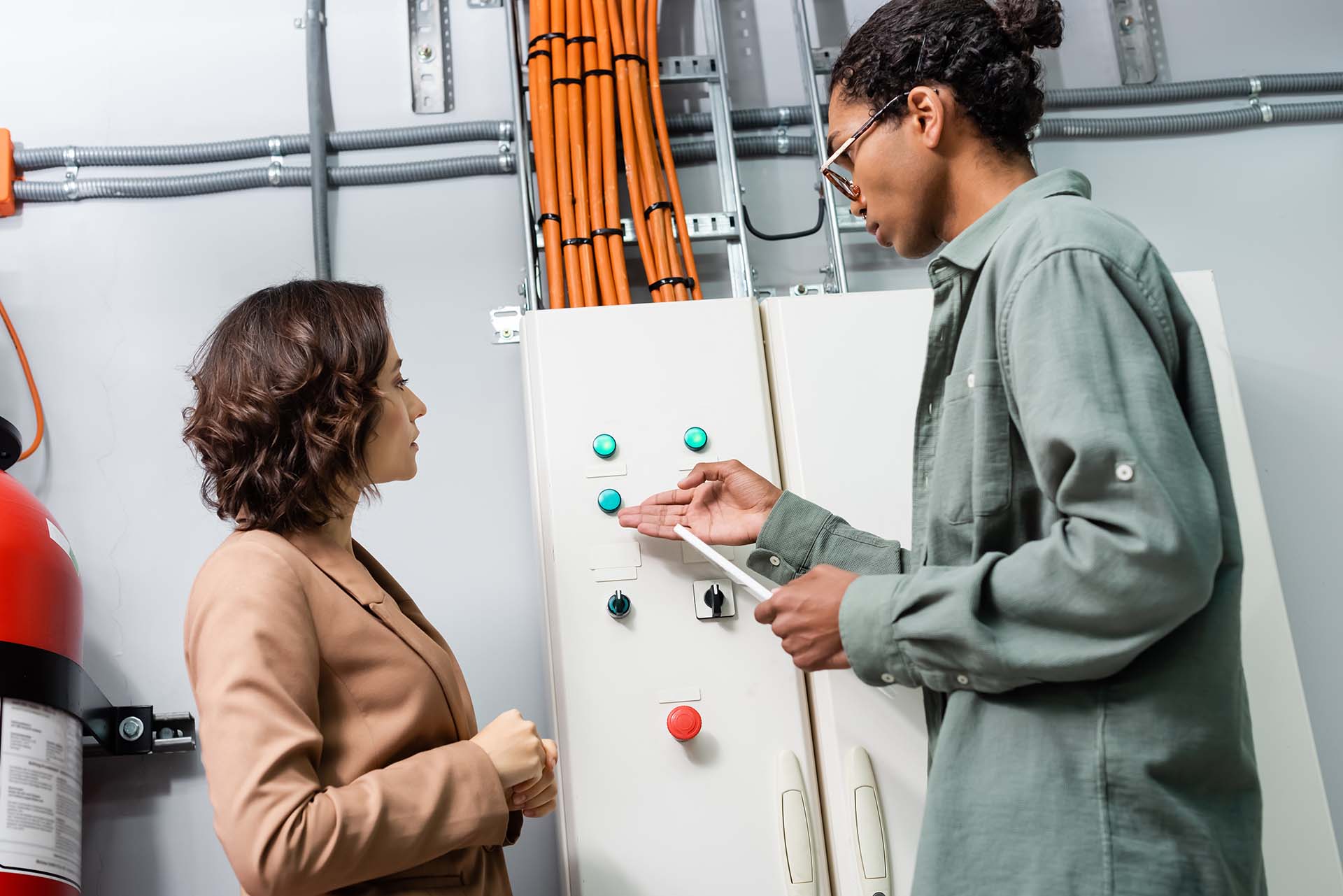 A technician explaining the condition of the switchboard with a female client.