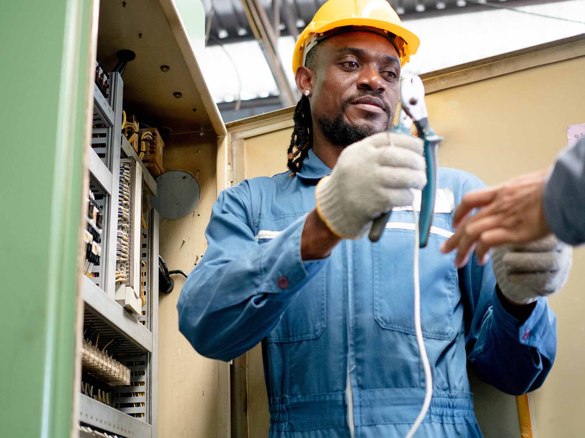 A technician is assessing the switch board.