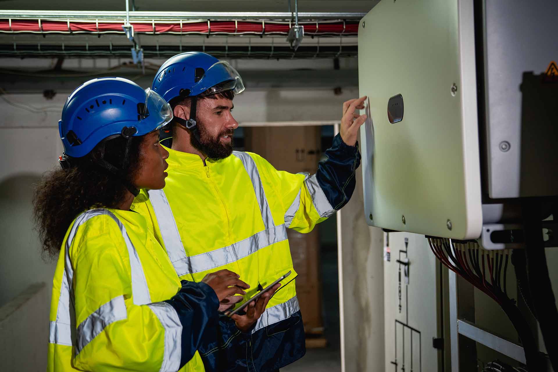 Two engineers are inspecting the switchboard.