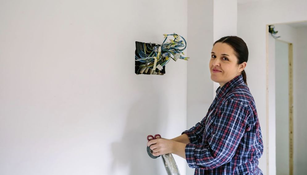 Female electrician next to open wires.