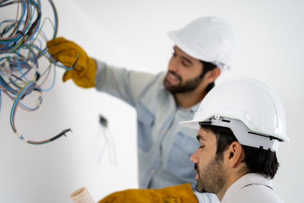 Men in hard hats working with wiring.