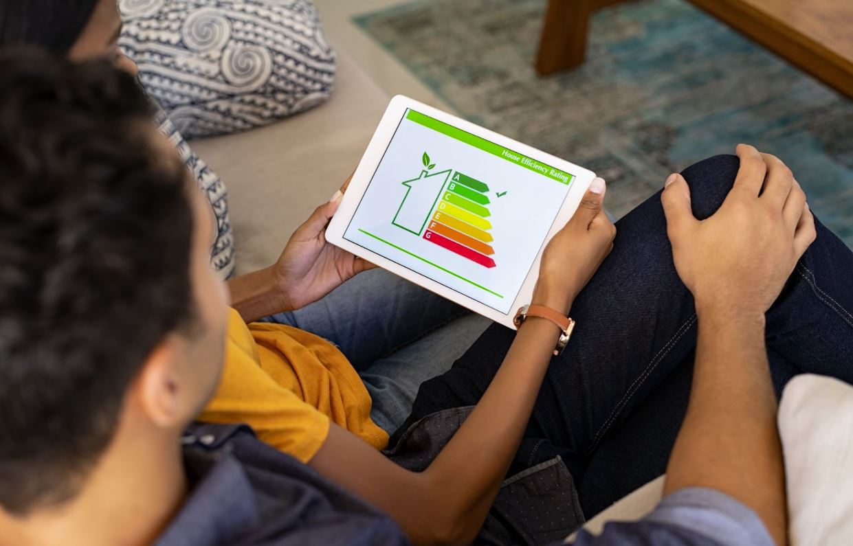 Couple checking their home’s energy consumption on an tablet with an outline of a home.