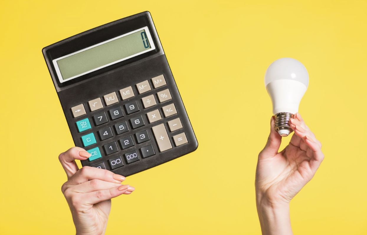 Woman holding a calculator and a lightbulb.